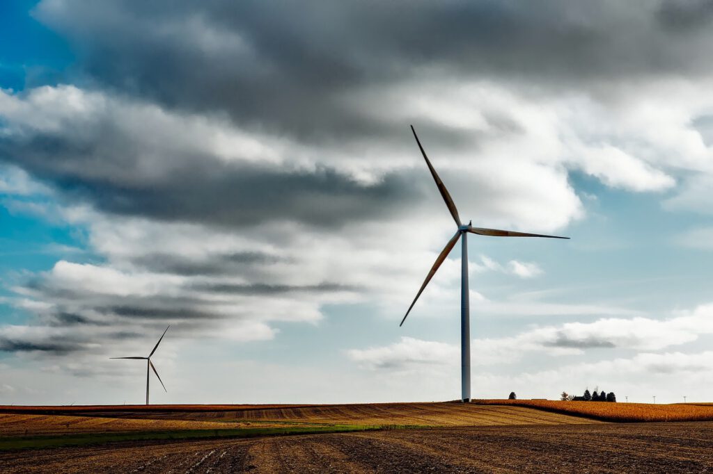 Photograph of windmills over farm fields with cloudy sky